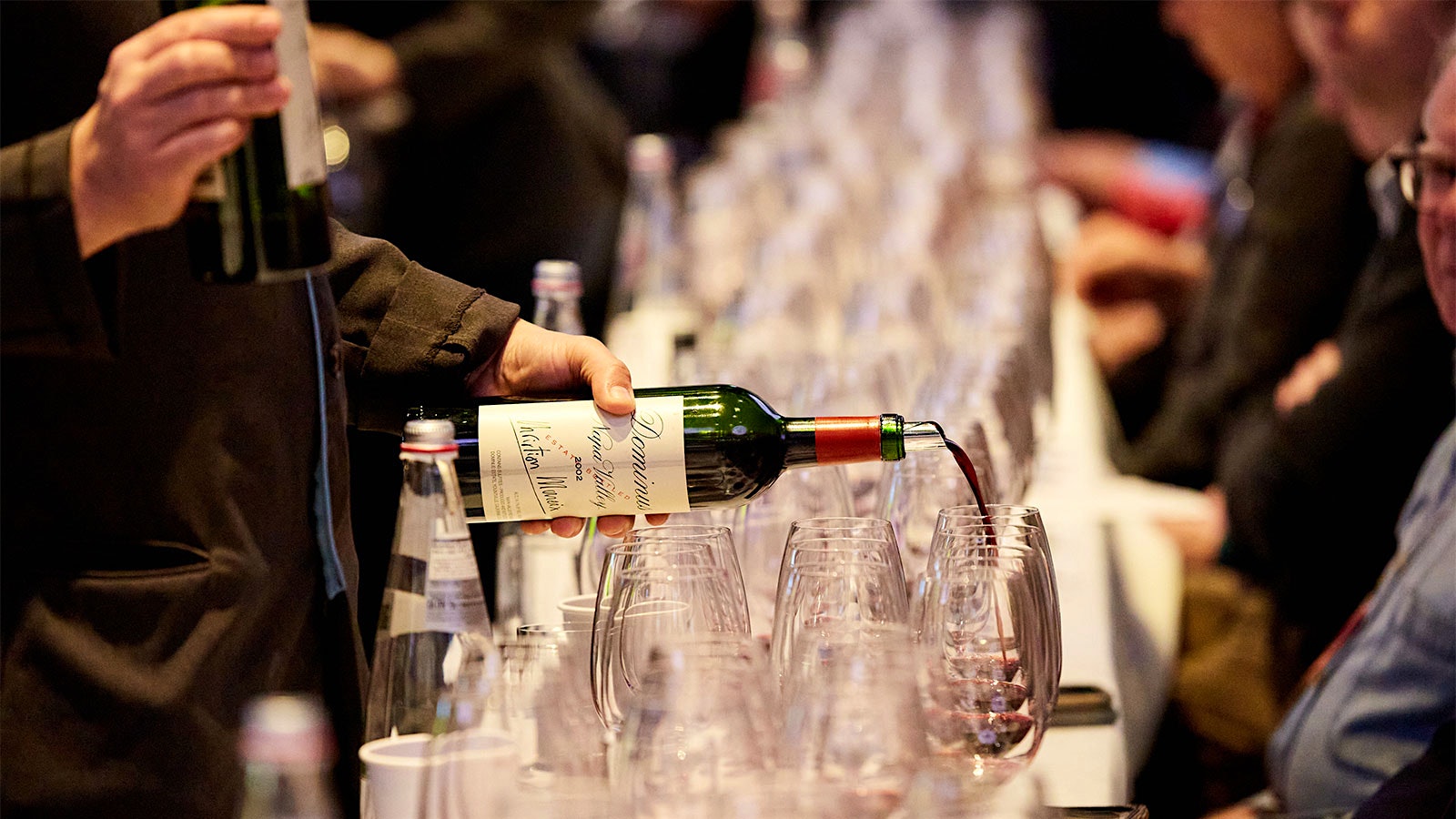 A server pours from a bottle of 2002 Dominus for guests at the 2022 New York Wine Experience